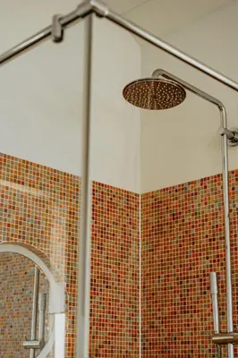 a bathroom with a shower with a tile wall at Apartment De Zeeparel by Interhome in Egmond aan Zee