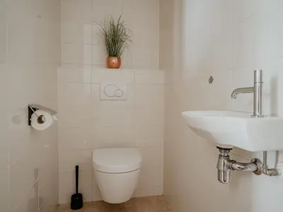 a bathroom with a toilet and a sink at Apartment De Zeeparel by Interhome in Egmond aan Zee