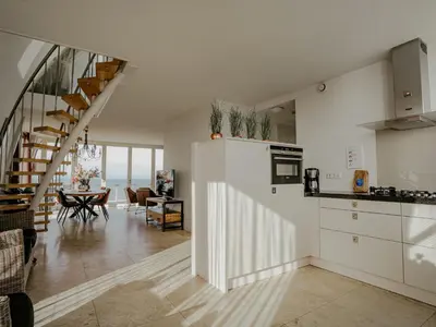 a kitchen and dining room with a staircase in a house at Apartment De Zeeparel by Interhome in Egmond aan Zee