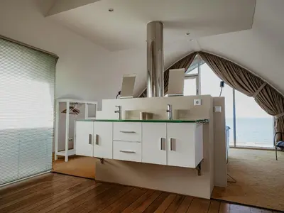 a kitchen with white cabinets and a large window at Apartment in Egmond with Sea Views in Egmond aan Zee
