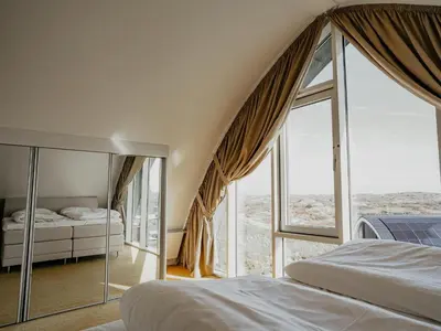 a bedroom with two beds and a large window at Apartment in Egmond with Sea Views in Egmond aan Zee
