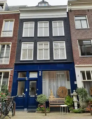 a house with blue doors and a cat sitting on a bench at Amsterdam Lily apartment in Amsterdam
