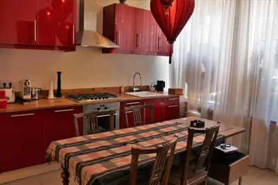 a kitchen with red cabinets and a table with chairs at Amsterdam Lily apartment in Amsterdam
