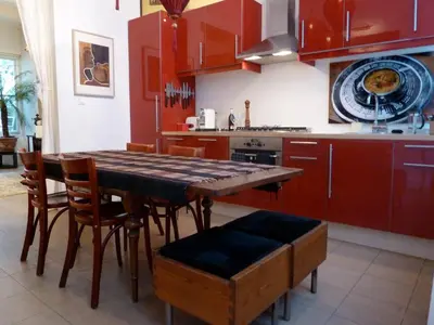 a kitchen with red cabinets and a wooden table and chairs at Amsterdam Lily apartment in Amsterdam