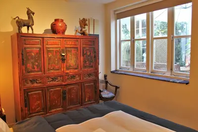 a bedroom with a large wooden cabinet with a window at Amsterdam Lily apartment in Amsterdam