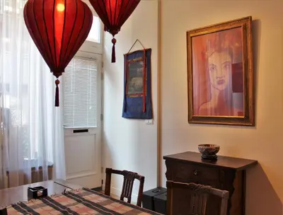 a dining room with a table and a painting on the wall at Amsterdam Lily apartment in Amsterdam