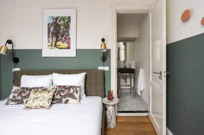 a bedroom with green and white walls and a bed with pillows at Numa Amsterdam Helmers in Amsterdam
