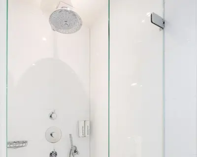 a shower with a glass door and a shower head at Numa Amsterdam Helmers in Amsterdam