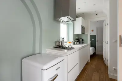 a kitchen with white cabinets and a stove at Numa Amsterdam Helmers in Amsterdam