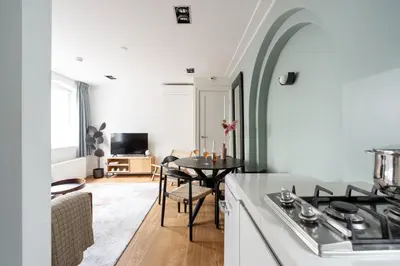 a kitchen and living room with a stove and a table at Numa Amsterdam Helmers in Amsterdam