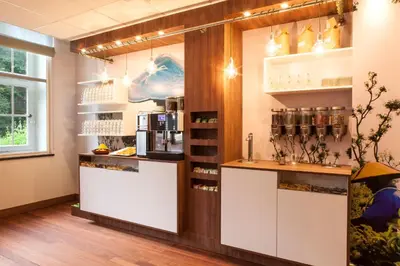 a coffee shop with a counter in a room at Hotel Kontakt der Kontinenten in Soesterberg