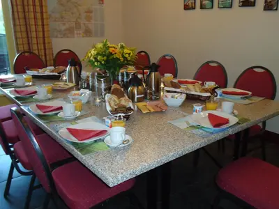 a table with red chairs around it with food on it at Hoeve Meerzicht in Monnickendam