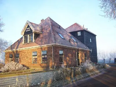 an old brick house with a shingled roof at Hoeve Meerzicht in Monnickendam