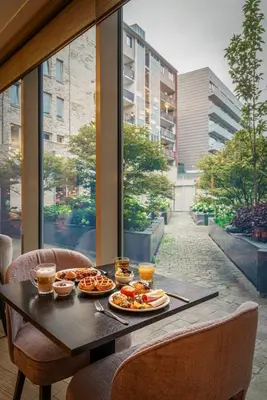 a table with plates of food and drinks on it at Monet Garden Hotel Amsterdam in Amsterdam