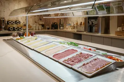 a buffet line with meat and other food items at Monet Garden Hotel Amsterdam in Amsterdam