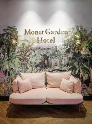 a couch in front of a wall with a mural at Monet Garden Hotel Amsterdam in Amsterdam