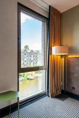 a room with a large window with a view of a building at Monet Garden Hotel Amsterdam in Amsterdam