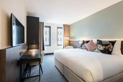 a hotel room with a large bed and a desk at Monet Garden Hotel Amsterdam in Amsterdam
