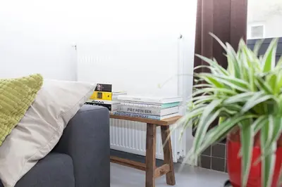 a table with books on it next to a couch at hip & stylish apartment in center, near trainstation, 15 min walk in Amsterdam