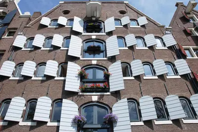 a building with windows and flowerpots on the facade at hip & stylish apartment in center, near trainstation, 15 min walk in Amsterdam
