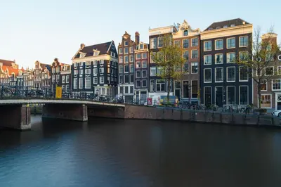 a bridge over a river in a city with buildings at 18th Century Groundfloor Canal House with patio/garden in Amsterdam
