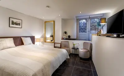 a bedroom with a bed and a flat screen tv at 18th Century Groundfloor Canal House with patio/garden in Amsterdam