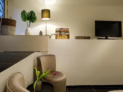 a waiting room with a chair and a tv at 18th Century Groundfloor Canal House with patio/garden in Amsterdam