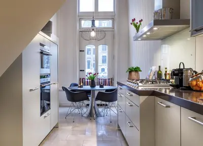 a kitchen with a table and chairs in it at 18th Century Groundfloor Canal House with patio/garden in Amsterdam