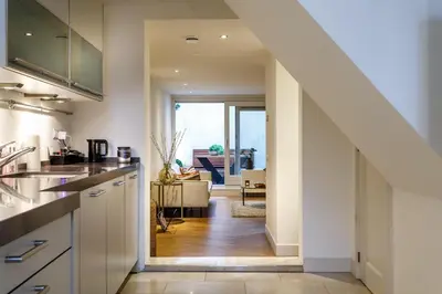 a kitchen with a staircase leading to a living room at 18th Century Groundfloor Canal House with patio/garden in Amsterdam