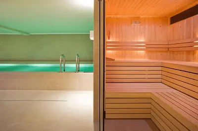 a sauna with wood paneling and a bath tub at Pestana Amsterdam Riverside in Amsterdam
