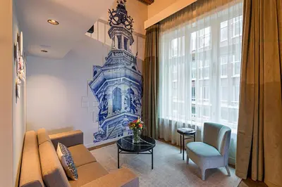 a living room with a couch and a window at Pestana Amsterdam Riverside in Amsterdam