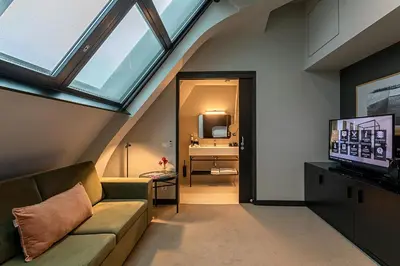 a attic living room with a couch and a television at Pestana Amsterdam Riverside in Amsterdam