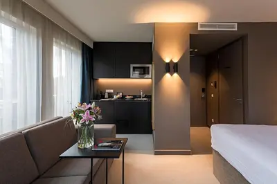 a living room with a couch and a table with flowers at Pestana Amsterdam Riverside in Amsterdam