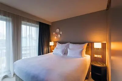 a hotel room with a large bed with white pillows at Pestana Amsterdam Riverside in Amsterdam