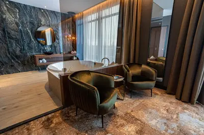 a bathroom with a tub and two chairs at Van Der Valk Hotel Almere in Almere