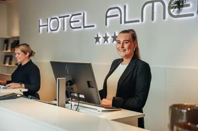 a woman sitting at a desk with a computer at Van Der Valk Hotel Almere in Almere