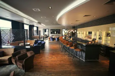 a restaurant with a bar with chairs and tables at Van Der Valk Hotel Almere in Almere