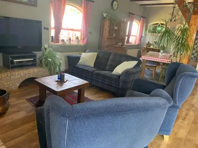 a living room with two couches and a tv at B&B De Kaagse Koe in Huigsloot