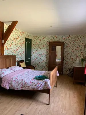 a bedroom with a bed and floral wallpaper at B&B De Kaagse Koe in Huigsloot