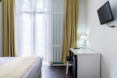 a hotel room with a bed and a desk and a television at Hotel Larende in Amsterdam