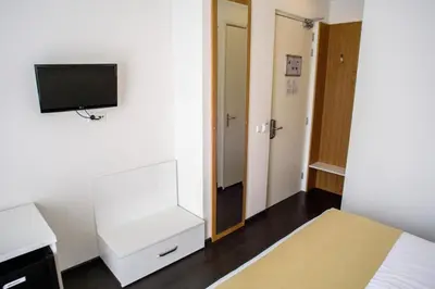 a bedroom with a bed and a tv on a wall at Hotel Larende in Amsterdam