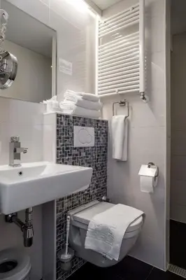 a white bathroom with a sink and a toilet at Hotel Larende in Amsterdam