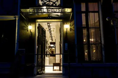 a store front with a sign for a criminal house at night at Canal House in Amsterdam
