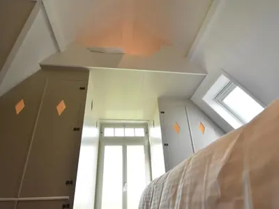a attic room with a bed and a window at Spacious Holiday Home in the Beemster near a Windmill in Middenbeemster