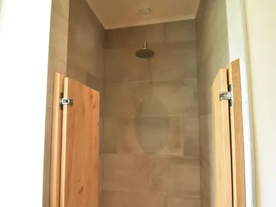a shower with a glass door in a bathroom at Spacious Holiday Home in the Beemster near a Windmill in Middenbeemster