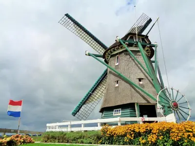 a windmill with a flag in front of it at Spacious Holiday Home in the Beemster near a Windmill in Middenbeemster