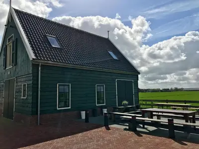 a green barn with a picnic table and a table at Spacious Holiday Home in the Beemster near a Windmill in Middenbeemster