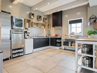a large kitchen with stainless steel appliances at Holiday Home in Beemster by Windmill in Middenbeemster