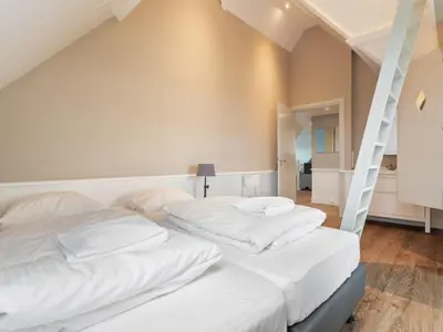 two beds in a room with white walls at Holiday Home in Beemster by Windmill in Middenbeemster