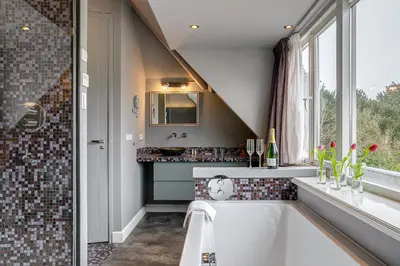 a bathroom with a tub and a sink and a window at Boutique Hotel 't Vosje in Haarlem
